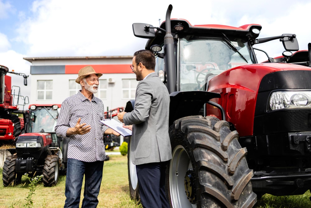 a man talking to a man standing next to a tractor